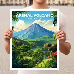 a man holding up a poster with the words arenaal volcano costa rica on it