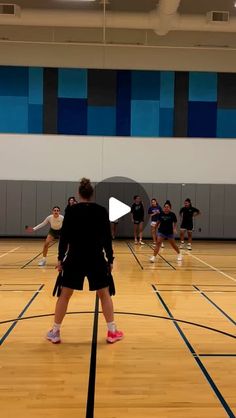 a group of people standing on top of a basketball court