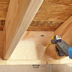 a person using a power drill to attach the insulation in a wooden structure that is being built