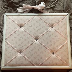 an upholstered photo frame with a bow on top