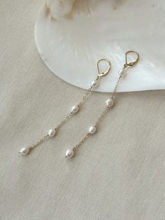 "These beautiful Pearl drop earrings are dainty and elegant. Each of the lustrous organic baroque pearls are hand wrapped in 14K Gold Filled or 925 Sterling Silver. The leverback is secure and stays in place all day! These earrings have beautiful movement and the dainty and durable chain adds a hint of sparkle! Choose from 2 different earring lengths! * 6mm round to oval Baroque Pearls * 14K Gold Filled or 925 Sterling accents * 3 Pearl Length - 2.75\" 4 Pearl Length - 3.75\" * Made with all hyp Delicate Linear Earrings With Ear Wire For Anniversary, Delicate Linear Earrings With Ear Wire For Formal Events, Delicate Linear Earrings With Ear Wire For Formal Occasions, Delicate Teardrop Linear Earrings For Anniversary, Delicate Linear Earrings For Anniversary, Dainty Bridal Earrings For Formal Occasions, Delicate Dangle Linear Earrings For Anniversary, Dainty Dangle Linear Earrings For Anniversary, Delicate Long Drop Linear Earrings For Anniversary