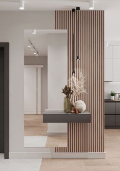 a modern kitchen with white walls and wood flooring, along with an open area for seating