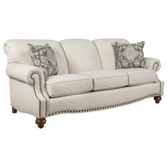 a white couch with pillows on it and two pillow cases around the armrests