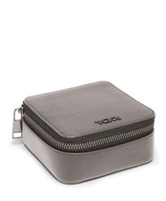 a small gray case with zippers on the front and side, sitting on a white surface