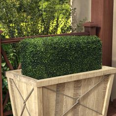 a boxwood planter is sitting on the porch