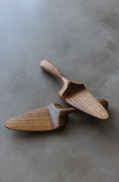 two wooden spoons sitting on top of a gray countertop next to each other