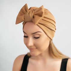 Satin lined turban cap with detachable bow. This turban cap is made with a soft and stretchy fabric. It is beautifully designed with a detachable bow in front and can be worn with or without the bow. Whether with hair up or down, indoors or outdoors, social and religious gatherings, bad and good hair days, this turban is what you need. Also perfect for women going through illness, chemo, alopecia.  This can indeed serve as a lovely gift for a woman in your life.  The satin lining helps protects One Size Beige Bonnet, Beach Turban With Knotted Detail, One Size Fits Most Beige Bonnet, Beige One Size Fits Most Bonnet, Adjustable Knotted Turban, One Size Chic Headwrap, Elegant Summer Headwrap Hat, Elegant Beanie-style Turban, Elegant One-size Beanie Turban