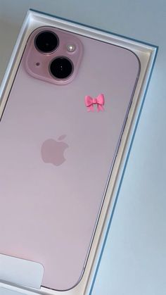 an iphone case with a pink bow on the front and back sides, sitting in a box