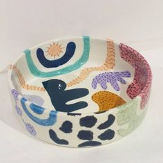 a white bowl with colorful designs on it