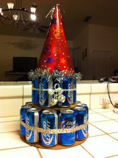 a birthday cake made out of cans with a party hat on top