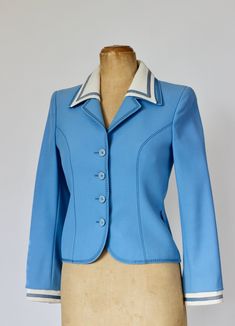 1960s Light blue suit wool jacket with beautiful details. White collar and cuffs. Closure with 4 buttons plus one spare ( all original) neatly still attached inside the jacket 2 Belt loops. Label: Ralph Creation, Germany Fabric: Pure New Wool  Fully lined: Viscose 100%   Estimated Size EU 36-38  - US 8, UK 12, please check measurements. The measures have been taken with the item flattened out (double bust and waist).  Arm pit to arm pit: 42 cm - 16,53 inches Waist  37 cm - 14,56 inches Length bag:  55 cm - 21,65 inches Sleeves:  57 cm - 22,44 inches Very good vintage condition. One tiny spot on the right side near the collar (see photo)  and pale yellowing inside the collar along the neck.  Follow us on Instagram @by_waltz https://www.instagram.com/by_waltz/ Vintage Blue Blazer For Workwear, Fitted Blue Blazer With Button Cuffs, Vintage Blue Blazer For Formal Occasions, Vintage Blue Blazer With Button Closure, Blue Wool Blazer With Button Cuffs, Vintage Blue Blazer With Notch Lapel, Fitted Retro Blue Blazer, Retro Fitted Blue Blazer, Light Blue Suit