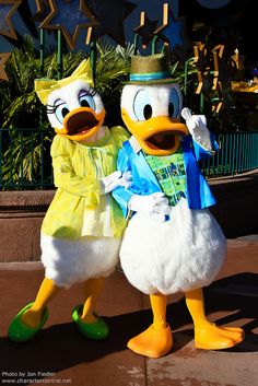 two donald and daisy duck characters standing next to each other