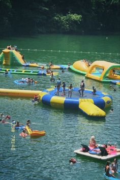 people are floating on inflatable rafts and having fun at the lake while others swim nearby