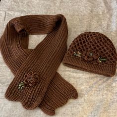 Chocolate Brown Knitted Hat And Matching Scarf. Hat Has Decorative Flower With Blue Bead Center And Green Knitted Leaves. Scarf Has Same Knitted Flower, Center And Leaf. Scarf Is 50” Long And 5&1/2” Wide. Hat Stretches To A Circumference Of 18” To 28”. New Without Tags. Knitted Leaves, Wide Hat, Leaf Scarf, Knitted Flowers, Handcrafted Accessories, Flower Center, Scarf Hat, Knitted Hat, Blue Beads