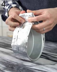 a person is wrapping silver foil around a can