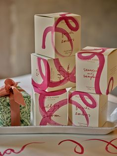 some boxes are stacked on top of each other and tied with pink ribbon around them