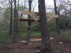 a wooden structure in the middle of a forest