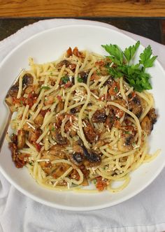 a white plate topped with pasta and mushrooms