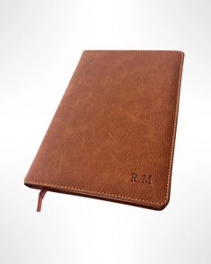 a brown leather notebook with the initials r m on it