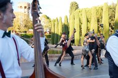 a group of people that are standing around with musical instruments in their hands and one person holding an instrument