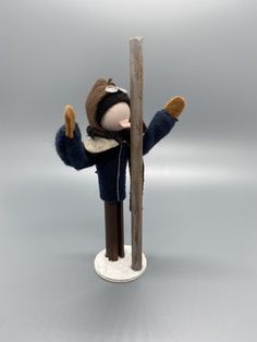 a doll is standing next to a pole with his arms up and hands in the air