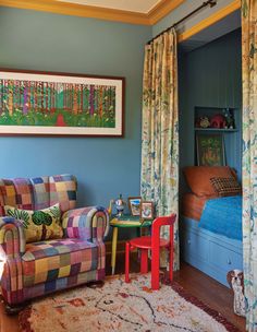 a living room with blue walls and colorful furniture