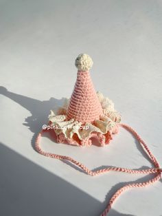 a crocheted pink hat with white trim