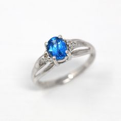 Stunning vintage 10k white gold created spinel and diamond accented ring! This unique modernist style piece features a created blue spinel center weighing 0.48 carats, and two sparkling diamond accents on either side weighing 0.01 carats each. The gemstones are all securely set in prong settings with a lovely, modern cathedral style tapered ring band. A beautiful piece of modern estate jewelry! *Sale - price reduced from $295 USD to $285 USD. ERA - Modern Estate METAL / MATERIAL - 10k white gold Modern Cathedral, Accented Ring, Modern Estate, Blue Spinel, Diamond Accent Ring, Jewelry Sale, Logo Gifts, Sparkling Diamond, Blue Gems