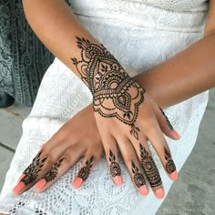 a woman's hand with henna tattoos on it