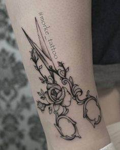 a tattoo with scissors and roses on it