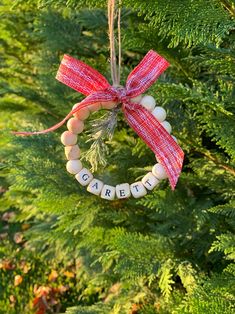 a christmas ornament hanging from a tree with the word care spelled on it