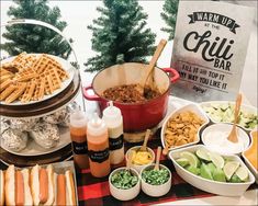 a buffet table filled with hot dogs, salads and condiments