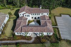 an aerial view of a home in the middle of a lot with lots of grass and trees