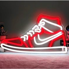 a pair of sneakers is lit up with red and white neon lights in front of a black background