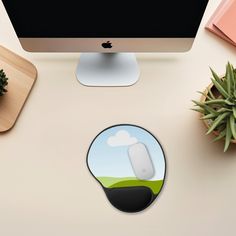 an apple computer monitor and mouse on a desk with other office supplies including a plant