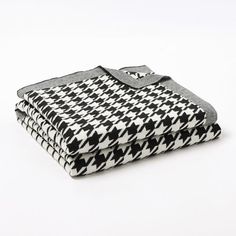 a blanket with black and white designs on the front, folded up in two rows