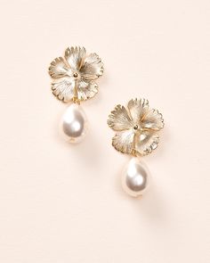 Bring a soft, feminine touch to your wedding day look with our Hayden Pearl Earrings. Each detailed metal flower is accented with an off white pearl drop that dangles effortlessly. Off white pearls Measures 1" x 1.5" long Hypoallergenic, lead-free & nickel-free Style #4456 Pearl Drop Bridal Earrings With Flower Shape, Delicate Pearl Drop Earrings With Flower Shape, Delicate Pearl Drop Earrings In Flower Shape, Delicate Flower Shape Pearl Drop Earrings, Feminine Pearl Drop Flower Earrings For Formal Occasions, Elegant Pearl Earrings With Flower Charm, Metal Jewelry With Flower Charm For Wedding, Wedding Jewelry With Metal Flower Charm, Pearl Drop Flower-shaped Bridal Earrings