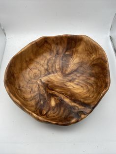 a wooden bowl sitting on top of a white box