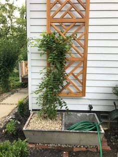 a planter with a hose attached to it in front of a house