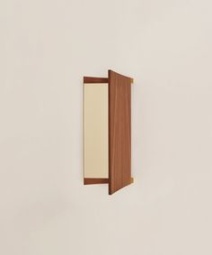 an open wooden door with a mirror on the wall in front of it that is white and brown