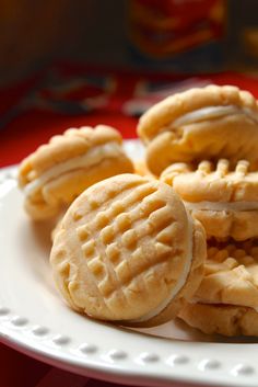 some cookies are on a white plate with red table cloth and a can in the background