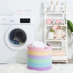 a washing machine next to a shelf with towels and stuffed animals on it in a white room