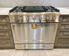 a stainless steel stove top oven sitting in a kitchen next to drawers and counter tops