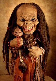 a creepy looking doll with dreadlocks holding a stuffed animal in it's hands