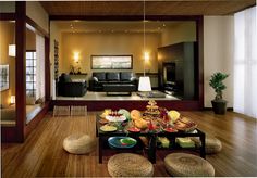 a living room filled with lots of furniture and food on top of a wooden table