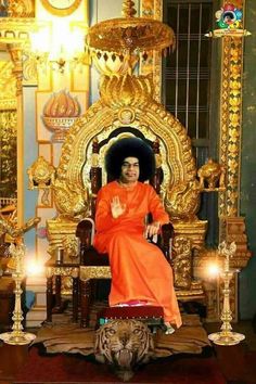 a man sitting on top of a chair in front of a golden throne with candles