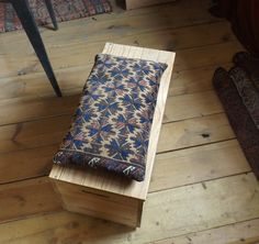 a wooden bench sitting on top of a hard wood floor next to a chair and rug