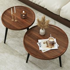 two wooden tables with magazines and candles on them in a living room or dining room