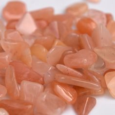 some pink and orange rocks on a white surface