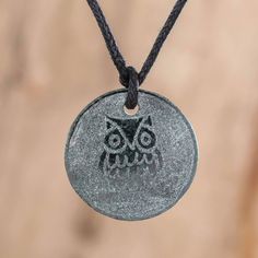 an owl pendant is hanging on a cord